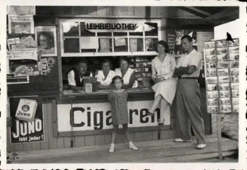 Foto Personen vor einem Kiosk mit Leihbibliothek