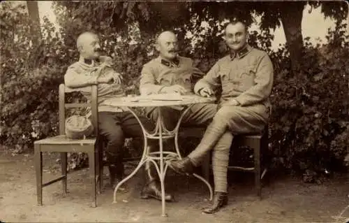 Foto Ak Drei KuK Soldaten an einem Tisch im Garten, I WK