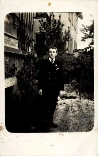 Foto Ak Junger Mann in einem Garten, Standportrait