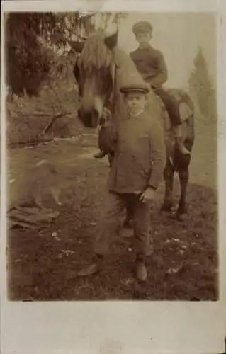 Foto Ak Zwei Kinder, Junge auf Pferd reitend