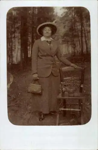 Foto Ak Frau im Wald, Porträt, Stuhl, Hut, Handtasche