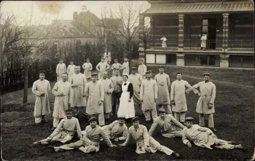 Foto Ak Deutsche Soldaten und Krankenschwester auf einer Wiese, Lazarett