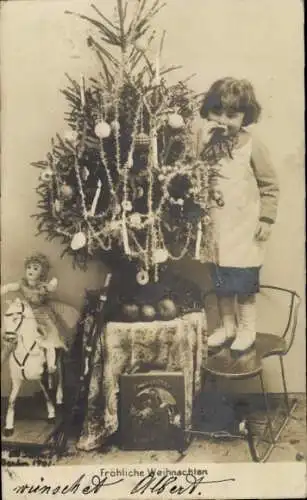 Ak Glückwunsch Weihnachten, Kind am Tannenbaum, Spielzeugpferd, Puppe