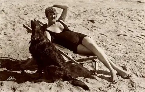 Ak Frau im Badeanzug im Liegestuhl am Strand, Sonnenbad, Hund