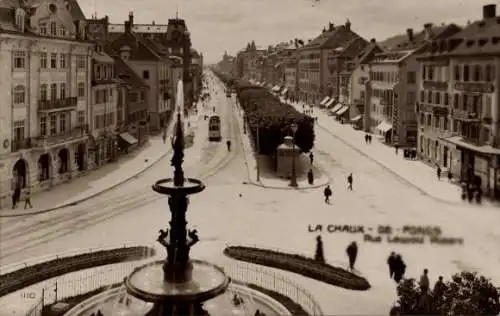 Ak La Chaux de Fonds Kanton Neuenburg, Monumentalbrunnen und Rue Léopold Robert, Straßenbahn