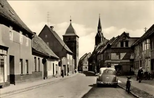 Ak Gräfenhainichen in Sachsen Anhalt, August Bebel Straße, Häuserpartie, Kirche