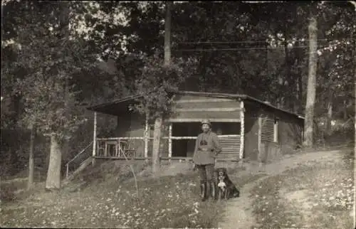 Foto Ak Deutscher Soldat mit Hund vor einer Hütte im Wald