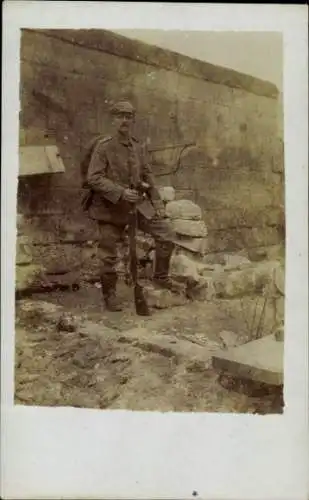 Foto Ak Deutscher Soldat in Uniform, Portrait vor einer Mauer