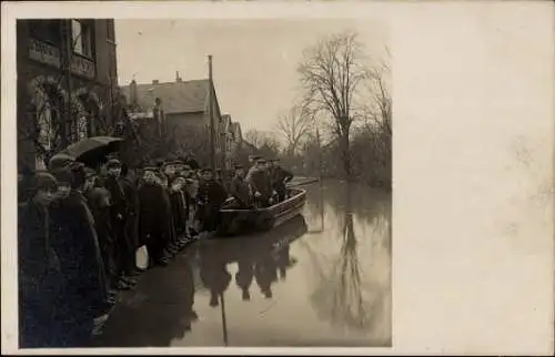 Foto Ak Göttingen, Hochwasser Februar 1909, Straßenpartie, Passanten auf einem Steg, Boot