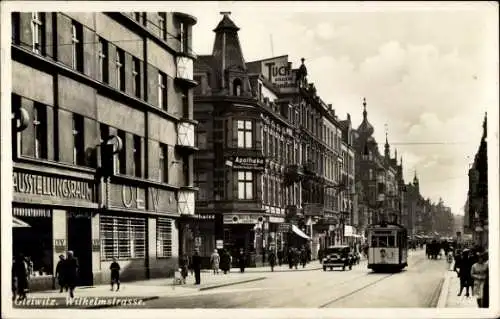 Ak Gliwice Gleiwitz Oberschlesien, Wilhelmstraße, Ausstellungsraum, Straßenbahn, Apotheke