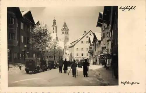 Foto Ak Kitzbühel in Tirol, Straßenpartie, Winteransicht, Kirchturm