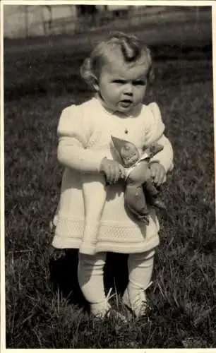 Foto Ak Kleinkind mit Puppe auf einer Wiese, Portrait