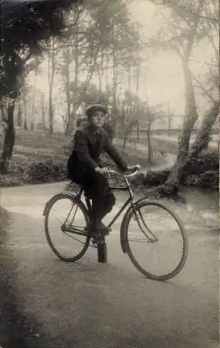 Foto Ak Junger Mann fährt Fahrrad, Waldpartie