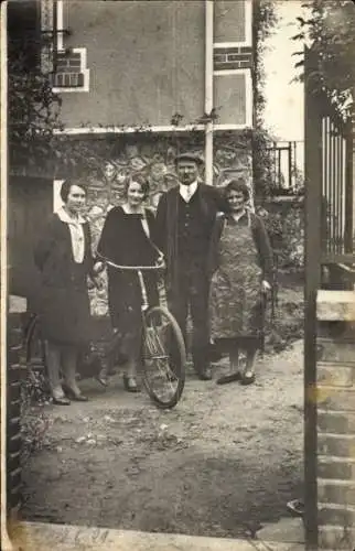 Foto Ak Mann und Frauen mit Fahrrad vor einem Wohnhaus