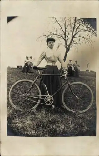 Foto Ak Frau mit Fahrrad auf einer Wiese