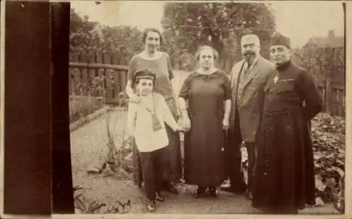 Foto Ak Geistlicher mit Familie in einem Garten