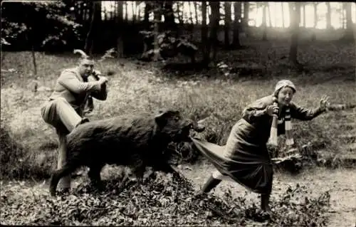 Foto Ak Wildschwein hält Frau am Rock fest, Mann vertreit es mit einer Keule