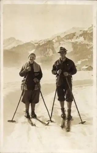 Foto Ak Mann und Frau auf Skiern im Gebirge