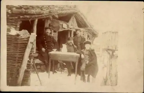 Foto Ak Deutsche Soldaten in Uniformen, Tisch, Holzhütte