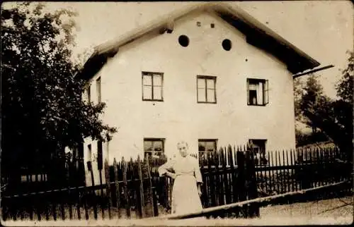 Foto Ak Arnbruck in Niederbayern, Frau am Zaun vor einem Wohnhaus