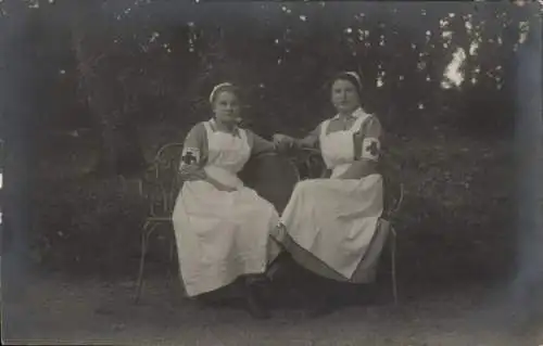 Foto Ak Zwei Krankenschwestern mit Armbinden, auf einer Bank, Park