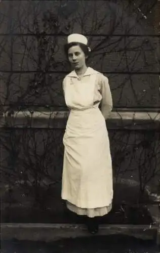 Foto Ak Krankenschwester in Dienstkleidung, Standportrait, Brosche Eisernes Kreuz