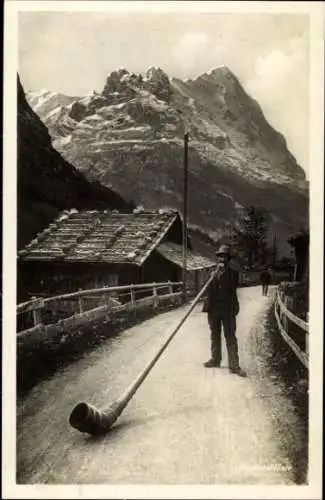 Ak Schweiz, Alphornbläser spielt im Gebirge, Sennhütte