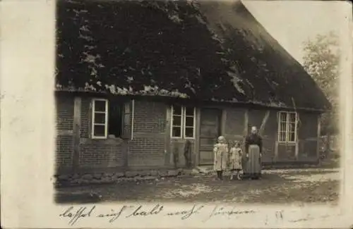 Foto Ak Grande in Schleswig-Holstein, Frau mit Kindern vor einem Haus