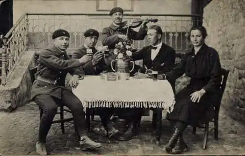 Foto Ak Soldaten, Mann im Frack und Frau an einem Tisch, geige