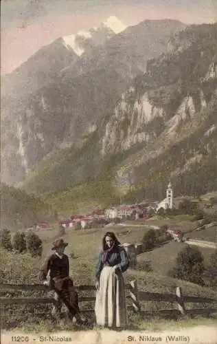 Ak St Nicolas St Niklaus Kanton Wallis, Gesamtansicht, Paar in Trachten, Gebirge