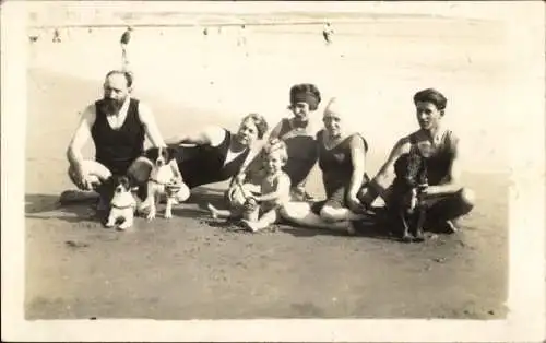 Foto Ak Personen in Badeanzügen mit Hunden am Strand