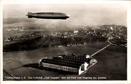 Ak Friedrichshafen am Bodensee,  Luftschiff LZ 127 Graf Zeppelin über der Werft, Fliegeraufnahme