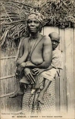 Ak Dakar Senegal, Barbusige Frau trägt Kind auf dem Rücken