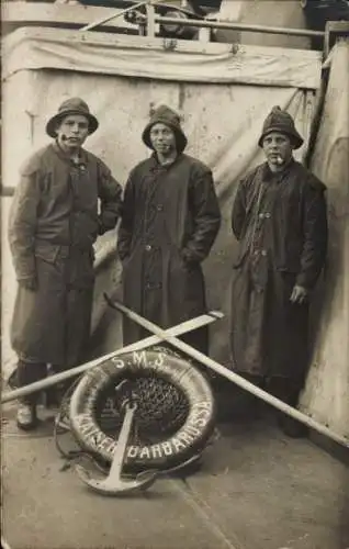 Foto Ak Deutsche Seeleute, Besatzung SMS Kaiser Barbarossa, in Regenmänteln, mit Pfeifen, Kiel