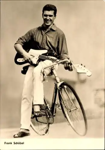 Ak Schauspieler und Sänger Frank Schöbel, Portrait mit Gitarre auf einem Fahrrad, Reise ins Ehebett