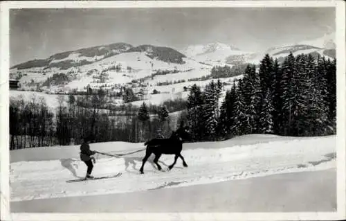 Ak Megève Haute Savoie, Skidjoering, Skifahrer lässt sich von Pferd ziehen