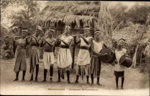 Ak Madagaskar, Musiker Betsimisaraka, Musiker mit Musikinstrumenten, Strohhütten