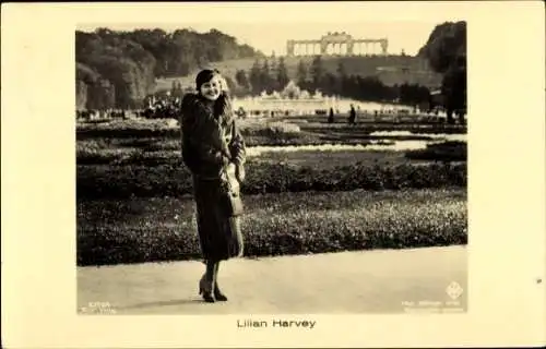 Ak Schauspielerin Lilian Harvey, Standportrait, Gartenanlagen