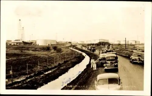 Foto Ak Lagunillas Venezuela, Straßenpartie, Autos, Silos