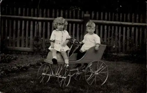 Foto Ak zwei Kleinkinder im Holzwagen mit Lenkrad und Hupe