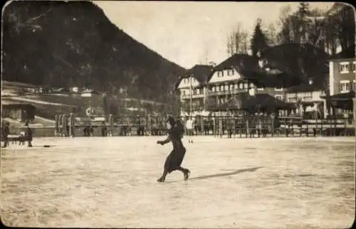 Ak Davos Kanton Graubünden, Eine junge Frau in schwarzem Kleid beim Schlittschuhlaufen auf ein...