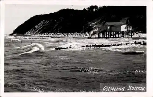 Ak Ostseebad Ahlbeck auf Usedom, Wellen schlagen ans Ufer, dahinter ein bebauter Hang