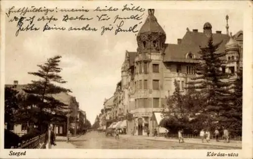 Ak Szeged Segedin Ungarn, Schwarz-weiß Foto einer Straße mit Bäumen, Häusern und Straßenbahn.