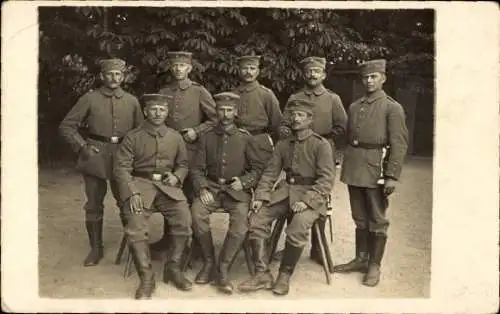 Ak Berlin Neukölln Rixdorf, Soldaten, stehend und sitzend, in Uniform mit Mütze und Gewehr.