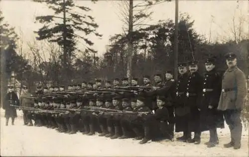 Foto Ak kaiserliche Infanterie posiert im Winter mit Waffe im Anschlag in Glücksburg