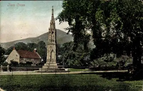 Ak Ilam Staffordshire England,  ein großes Steinkreuz in einer kleinen Ortschaft, dahinter ein...