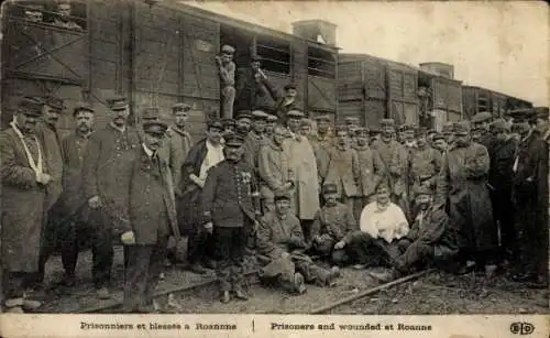 Ak Roanne Loire, Gruppenfoto, gefangene und verwundete Soldaten, Waggons im Hintergrund, histo...