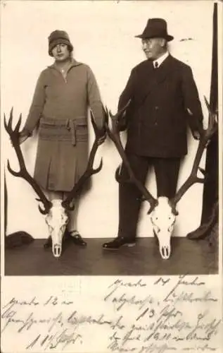 Foto Ak Frau und Mann halten Hirschgeweihe, Standportrait, Jagd