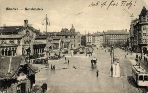 Ak München,  Bahnhofplatz mit Straßenbahn, Personen, Pferdekutschen und Gebäuden