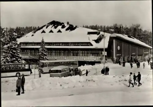 Ak Oberhof im Thüringer Wald, verschneite Straße mit Bussen und Menschen davor, rechts ein gro...